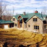 Back elevation of the home, and garage with log siding.